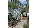 Inviting two-story home with white siding, front porch, and beautifully landscaped yard at 324 Wild Horse Ln, Mount Pleasant, SC 29464