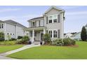 Attractive two-story home with gray siding, well-kept lawn, tasteful landscaping, and charming covered front porch at 3998 Capensis Ln, Ravenel, SC 29470