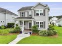 Beautiful two-story home featuring a landscaped yard, inviting porch, and classic architectural details for great curb appeal at 3998 Capensis Ln, Ravenel, SC 29470