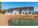 Rear view of new townhomes feature neutral siding, back patios and views of a small pond at 424 Duskywing Dr, Goose Creek, SC 29445