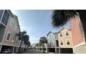 Street view of charming townhomes with colorful exteriors and palm trees, creating a vibrant and inviting community atmosphere at 81 Sandbar Ln # 28, Folly Beach, SC 29439