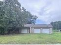 Three car garage surrounded by lots of grass and trees at 838 Ranch Hill Ln, Saint Stephen, SC 29479