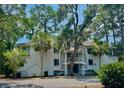 Multi-Gathering residence surrounded by lush greenery and mature trees at 855 Club Cottage Rd, Edisto Island, SC 29438