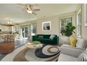 Comfortable living room with stylish decor, a green sofa, and an open floor plan leading to the dining area at 8621 Connor Ct, North Charleston, SC 29406