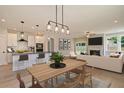 Open-concept kitchen, dining, and living area boasts hardwood floors, modern lighting, and stainless steel appliances at 8629 Connor Ct, North Charleston, SC 29406