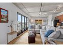 Bright living room boasts large windows, exposed ceilings, hardwood floors, and comfortable seating at 1 Cool Blow St # 153, Charleston, SC 29403
