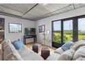 Airy living room featuring neutral colors, exposed ceilings, and abundant natural light from expansive windows at 1 Cool Blow St # 153, Charleston, SC 29403
