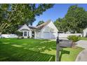 A single-Gathering home with attached garage, mature trees, and green lawn under a bright blue sky in a suburban setting at 103 Case Ct, Ladson, SC 29456