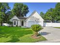 Charming single-Gathering home featuring an attached two-car garage, well-maintained lawn, and a mature palm tree at 103 Case Ct, Ladson, SC 29456