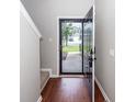Inviting front entrance featuring wood flooring and a storm door, providing a glimpse of the neighborhood beyond at 107 Brookhaven Rd, Summerville, SC 29486