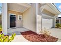 Home exterior with black front door, attached garage, and manicured landscaping at 110 Cardinal Flower Ct, Moncks Corner, SC 29461