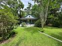 A single-story bungalow-style house with a quaint front porch, surrounded by a lush lawn and greenery at 1640 Dogwood Rd, Charleston, SC 29414