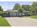 Charming blue home boasts a well-manicured lawn and a large concrete driveway and inviting curb appeal at 2605 Mona Ave, Charleston, SC 29414