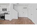 Open-concept living space features luxury vinyl flooring, a staircase, and a kitchen area with stainless steel appliances at 491 Cedarview Rd, Summerville, SC 29486