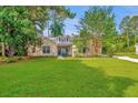 Attractive single-story home featuring a well-manicured lawn and inviting blue chairs at 5023 Manor Rd, Hollywood, SC 29449