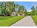 Cozy one-story home with a long driveway leading to a basketball court at 5023 Manor Rd, Hollywood, SC 29449