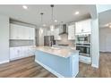 Beautiful kitchen with stainless steel appliances, large island and modern pendant lights at 504 Sarno Way, Summerville, SC 29486