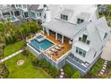 Aerial view of a home's backyard with a pool, hot tub, outdoor seating area, and lush greenery at 553 Old Compass Rd, Daniel Island, SC 29492