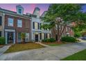 Exterior of townhouses with brick facade and manicured lawns, set against a vibrant evening sky at 765 Certificate Ct, Charleston, SC 29414