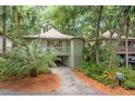 Picturesque raised home featuring a drive-through carport, mature trees, and lush, well-maintained landscaping at 1025 Scaup Ct, Kiawah Island, SC 29455