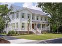 Charming two-story home with a metal roof, lush lawn, and inviting front porch at 108 Live Oak Dr, Mount Pleasant, SC 29464