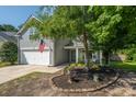 Traditional two-story home featuring a garage, well-manicured lawn, and lovely landscaping at 108 Plume Poppy Ln, Ladson, SC 29456