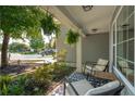 Relaxing front porch area featuring comfortable seating and views of the landscaped front yard at 108 Plume Poppy Ln, Ladson, SC 29456