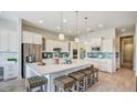 Open-concept kitchen featuring large quartz island, stainless steel appliances, stylish light fixtures, and bar stool seating at 113 Magnolia House Dr, Summerville, SC 29486