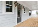 Charming front porch showcasing the front door and stylish lighting fixtures at 1655 Cultivation Ln, Mount Pleasant, SC 29466