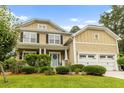 Attractive two-story home with a two-car garage, lush landscaping, and a welcoming front porch at 188 Donning Dr, Summerville, SC 29483