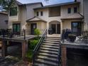 Exterior view of a multi-story condo building featuring stairs to the units and mature landscaping at 1919 Marsh Oak Ln, Seabrook Island, SC 29455