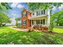 Charming two-story home with a lush green lawn, flowerbeds, and front porch with stairs at 2026 Thornhill Dr, Summerville, SC 29485