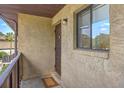 Condo exterior featuring tan stucco, a unit entrance door, and a window with a view of palm trees at 2174 Bees Ferry Rd # G, Charleston, SC 29414