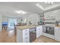 Open kitchen with white cabinets, wooden countertop, stainless steel dishwasher, and a view into the dining area at 2174 Bees Ferry Rd # G, Charleston, SC 29414