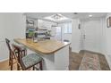 Bright kitchen featuring white cabinets, a butcher block countertop island with bar stool seating at 2174 Bees Ferry Rd # G, Charleston, SC 29414