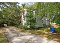 View of side yard with mature trees and large driveway with basketball court, attached to the home's exterior at 2217 Ramsay St, Charleston, SC 29412