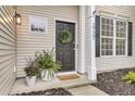Inviting front door adorned with a wreath, complemented by potted plants and stylish house numbers at 2727 Four Winds Pl, Mount Pleasant, SC 29466