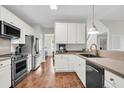 Modern kitchen with stainless steel appliances, white cabinetry, and beautiful hardwood floors at 2727 Four Winds Pl, Mount Pleasant, SC 29466