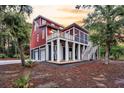 Lovely two-story home featuring a screened porch, deck, and a three-car garage, surrounded by trees at 4352 Park Island Rd, Hollywood, SC 29449