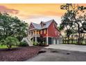 Beautiful two-story home with a metal roof, inviting front porch, and a three-car garage at 4352 Park Island Rd, Hollywood, SC 29449