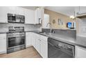 Modern kitchen features stainless steel appliances, white cabinets, granite countertops, and an eat-in bar at 513 Sea Foam St, Summerville, SC 29486