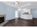 Relaxing living space with a fireplace, ceiling fan, and wood floors, leading to the kitchen and other rooms at 60 Fenwick Hall Allee # 738, Johns Island, SC 29455