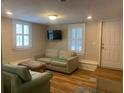 Inviting living room with wood floors, shuttered windows and comfortable seating arrangements at 65 Vanderhorst St # C, Charleston, SC 29403