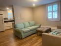 Cozy living room featuring hardwood floors and a comfortable couch beneath a window at 65 Vanderhorst St # C, Charleston, SC 29403