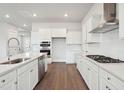 Bright, spacious kitchen features white cabinets, stainless steel appliances, quartz countertops, and wood floors at 88 French Garden Cir, Summerville, SC 29486