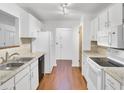 Well-lit kitchen with white cabinets, modern appliances, laminate countertops, and wood-look laminate flooring at 103 Greencastle Dr, Goose Creek, SC 29445