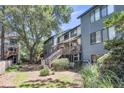 Rear exterior view of a townhouse with a wooden deck, stairs, and natural, shaded landscaping at 1120 Hidden Cove Dr # I, Mount Pleasant, SC 29464