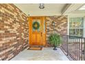 Charming front entrance with a wooden door, decorative wreath, and brick facade at 133 Axtell Dr, Summerville, SC 29485