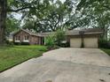 Inviting single-story brick home with attached two-car garage and lush landscaping along driveway at 1389 Parkshore Dr, Charleston, SC 29407
