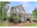 Inviting two-story home with a covered front porch, American flag, and lush, green landscaping at 1728 Wellstead St, Mount Pleasant, SC 29466